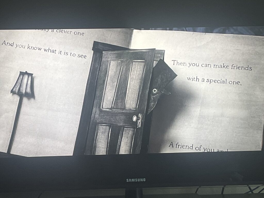 Screenshot from The Babadook: The Babadook storybook with the tophat man peeking out from behind a paper door, close-up.